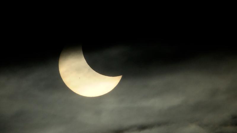 Cloud breaks bring cheers from partial solar eclipse watchers | 104.7 ...